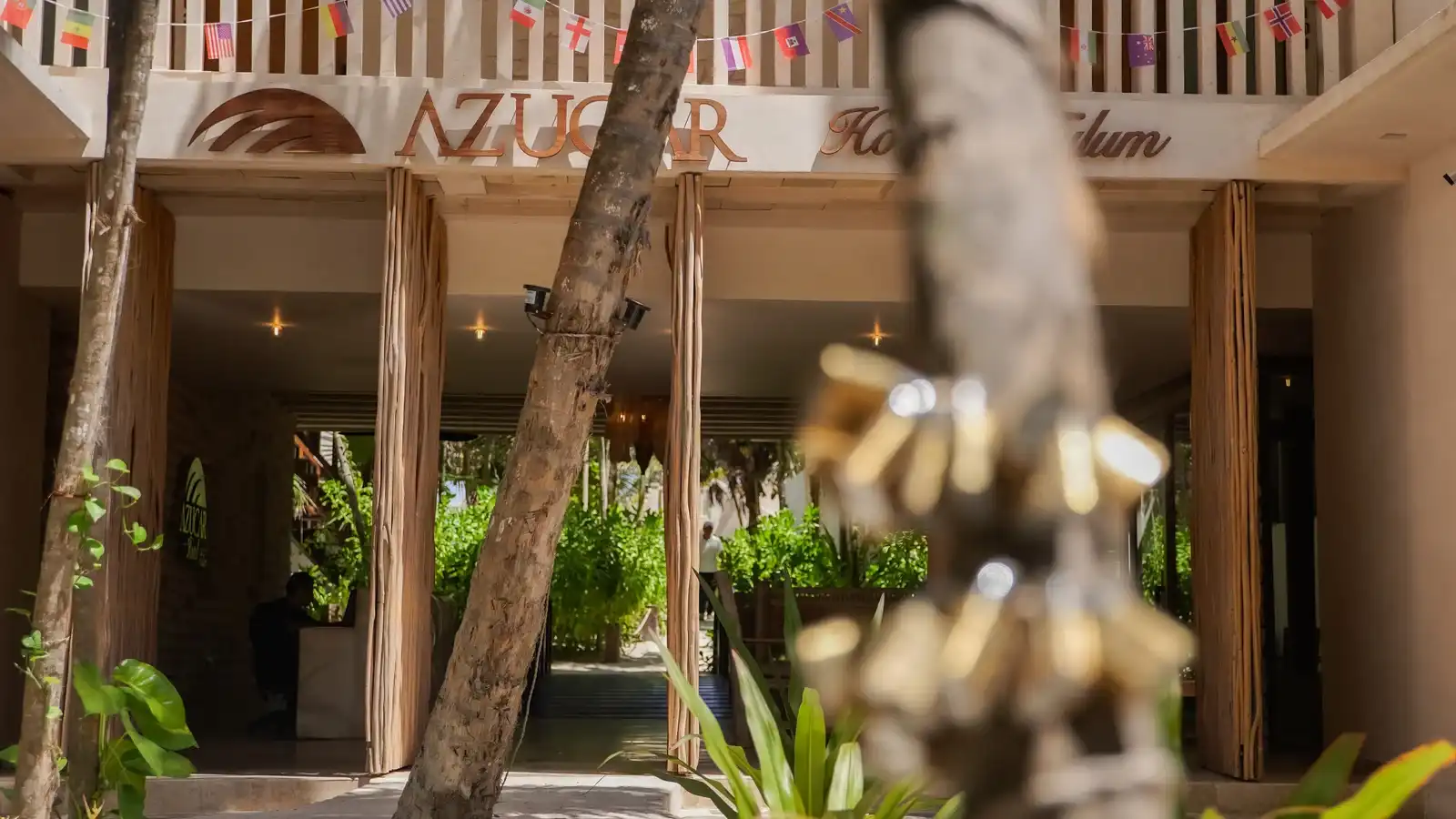 Entrada del hotel con el rótulo y una guirnalda de banderines de papel picado.