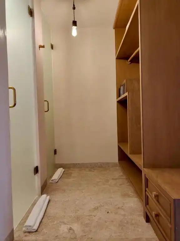Pasillo del cuarto con el clóset abierto y una lámpara colgante.