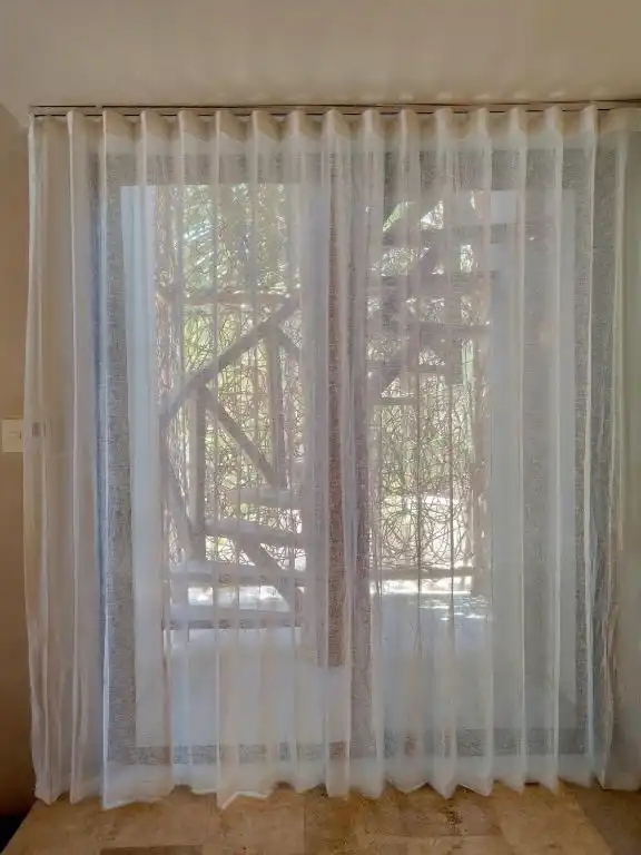 A sheer curtain in front of the balcony window wall.