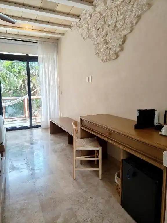 A wooden desk beside the balcony window wall.