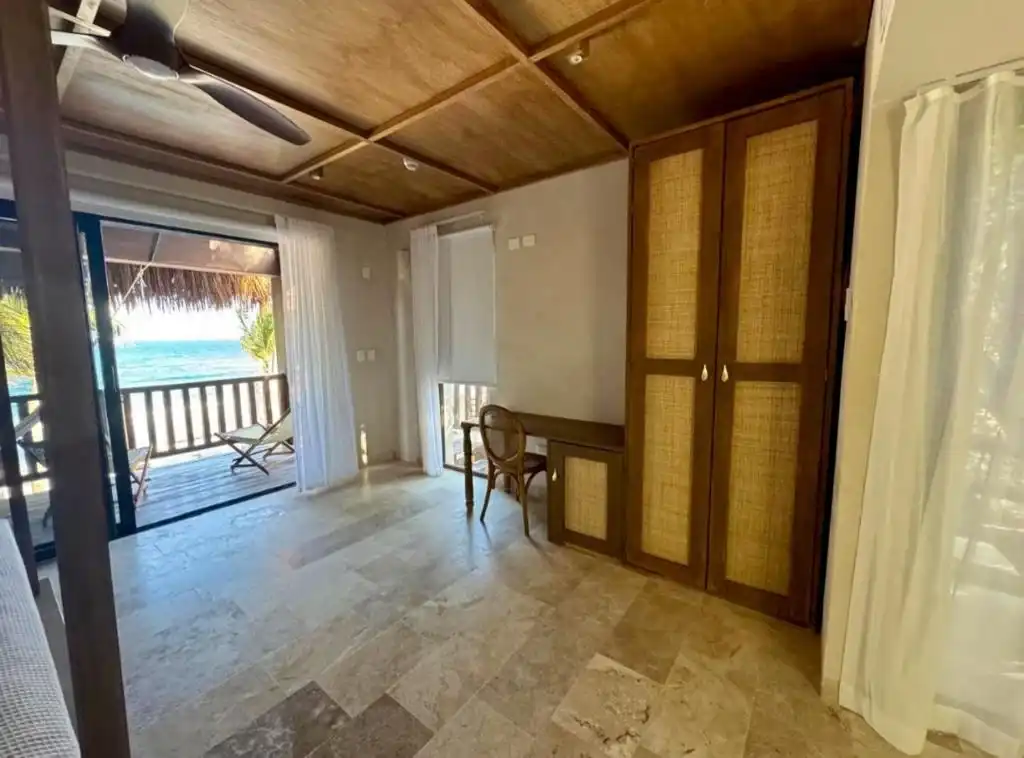 A room with a wooden ceiling, a closet and a way out to the balcony.