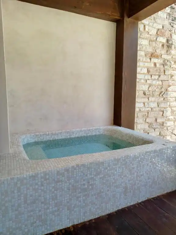 A mosaic jacuzzi on a stone terrace.