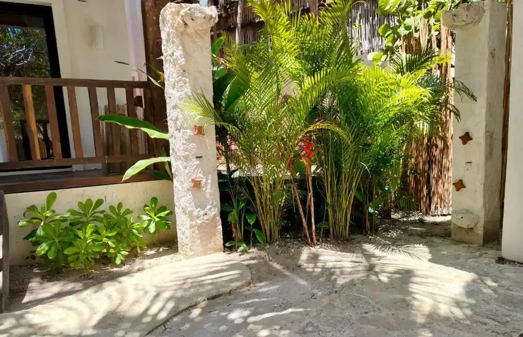 A stone column and greenery beside the terrace.
