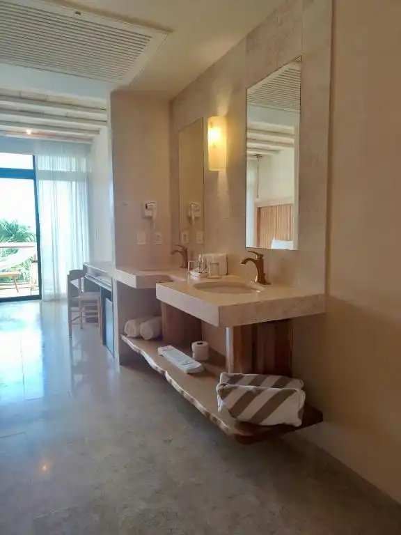 A stone washbasin in front of the window wall.