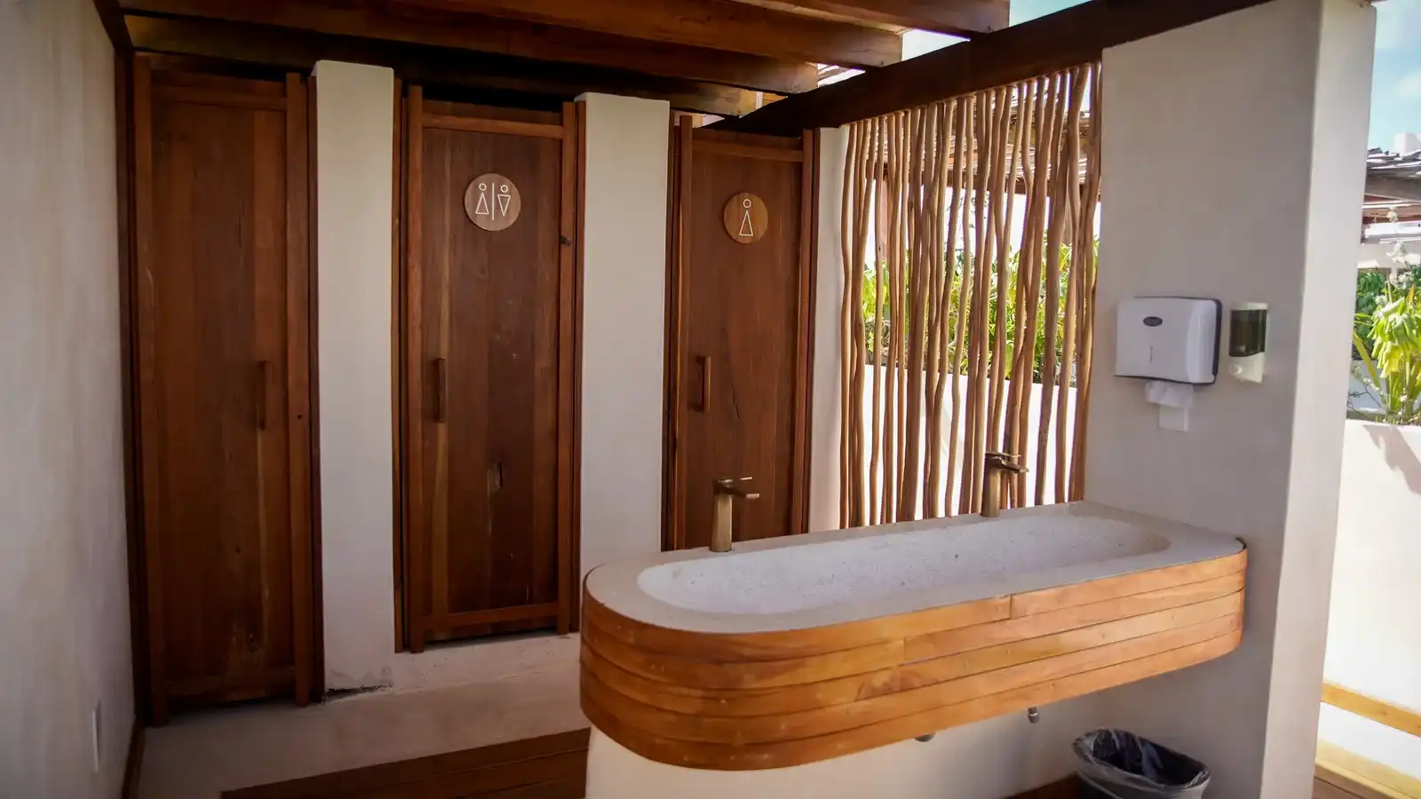 A bathroom with wooden doors and a masonry bathtub edged in wood.