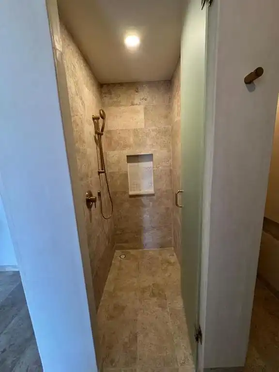 A narrow passage to the shower, with stone walls.