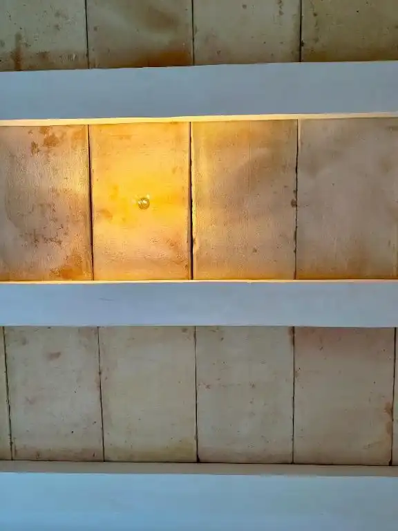 A headboard of wooden panels, lit from below.