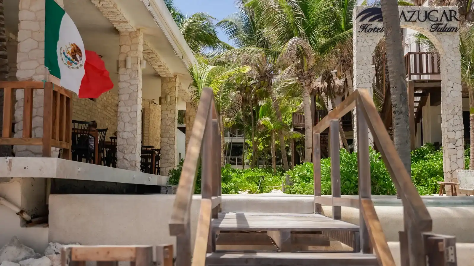 The hotel entrance with the Mexican flag and the sign above the wooden staircase.