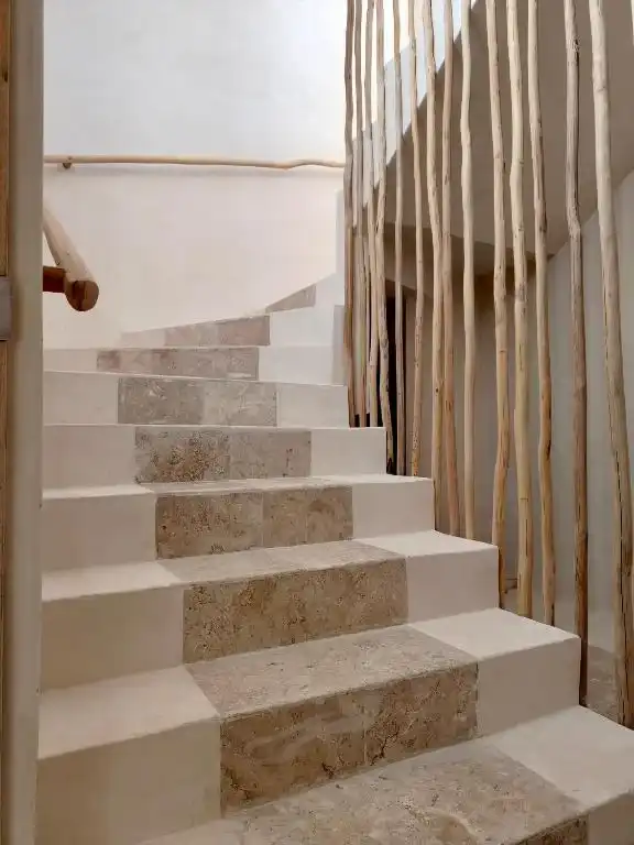 A stone staircase with a railing of tree trunks.