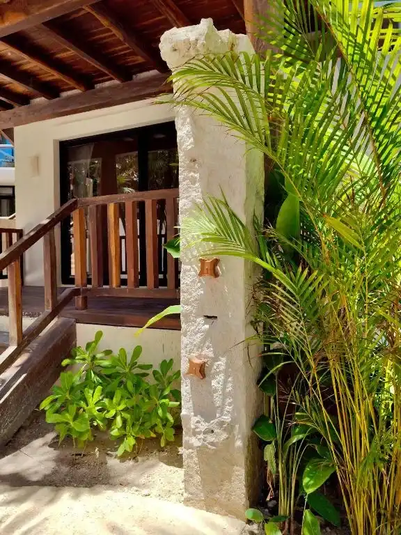 An outdoor staircase with a stone column and greenery.