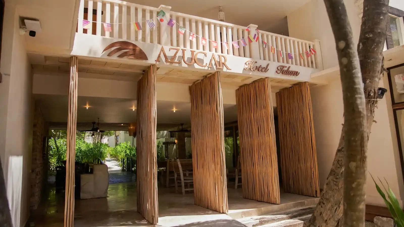 The hotel facade with its sign, papel picado bunting and wooden columns.