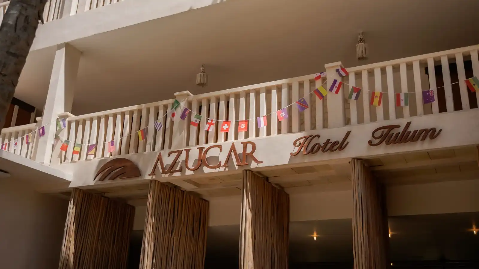 The hotel facade with the “Azucar Hotel Tulum” sign above the columns.