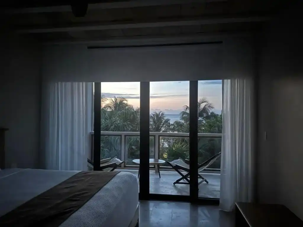 A dim room, with the window wall open onto the sunset.