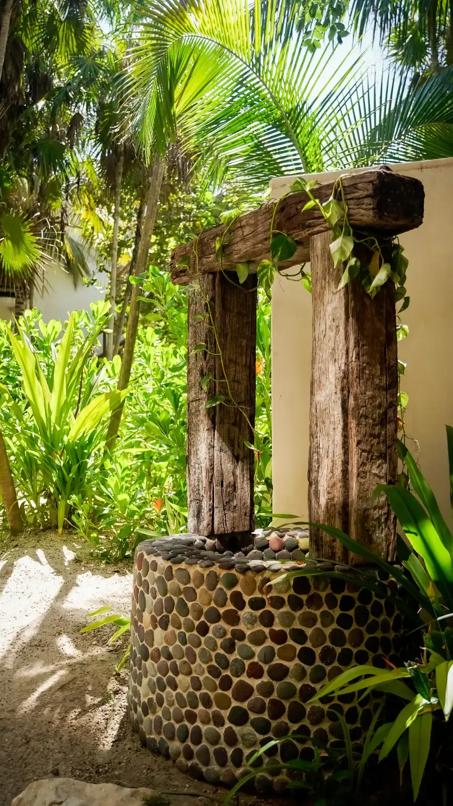 A stone well with a wooden lintel, surrounded by greenery.