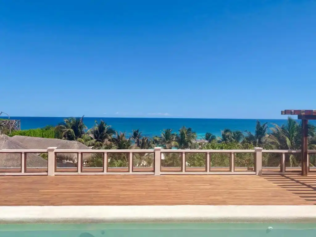 Wooden decking beside the pool, with the sea beyond.