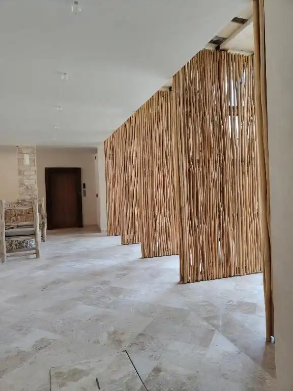 An interior passage with bamboo panels and a wooden door.